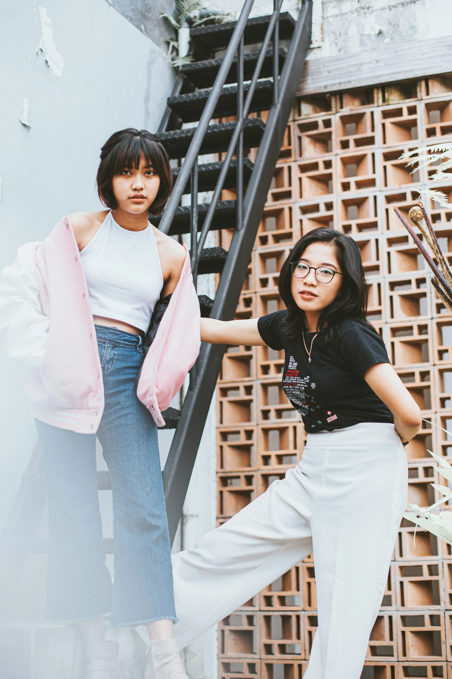 two women standing in front of a staircase