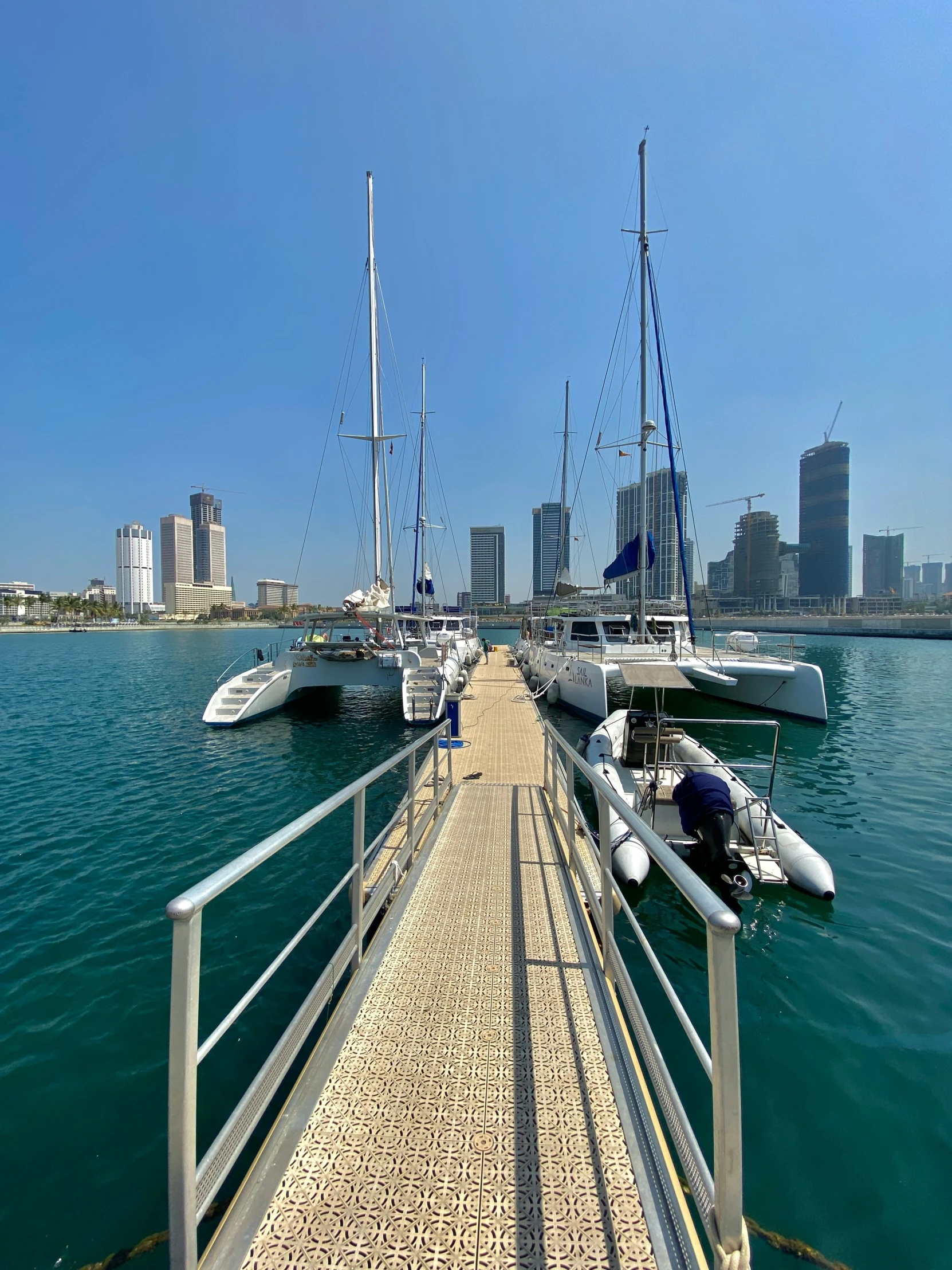 a long dock with boats in it in the middle of the ocean