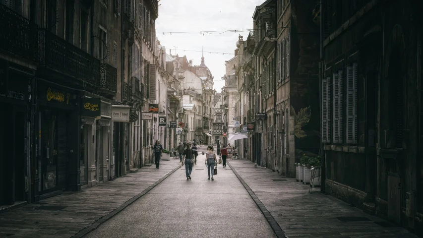 two people walk down an empty street during the day