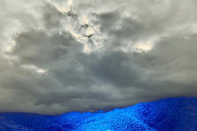 a blue cloud hovers above a mountain range