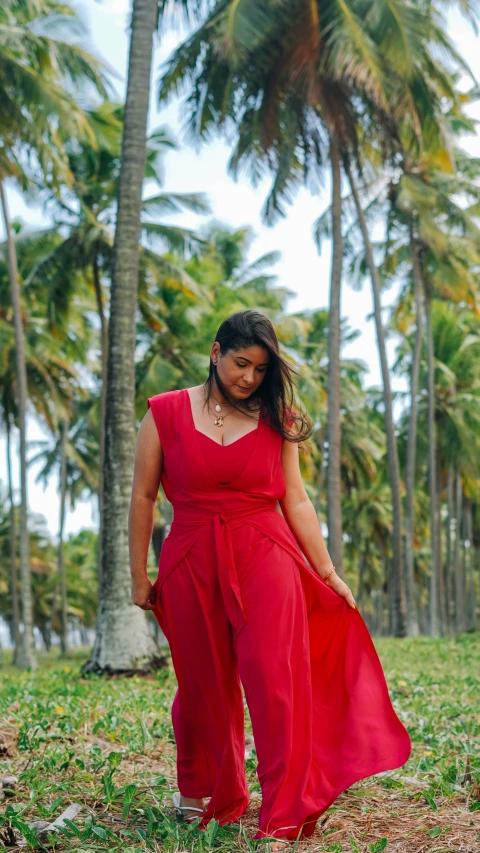 a woman is wearing a red dress next to the ocean