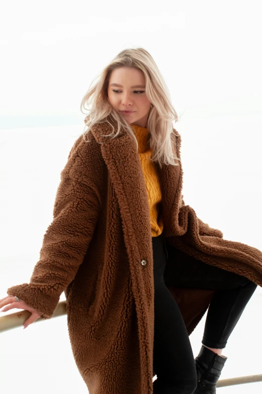 a blonde woman in a fuzzy cardigan poses for the camera