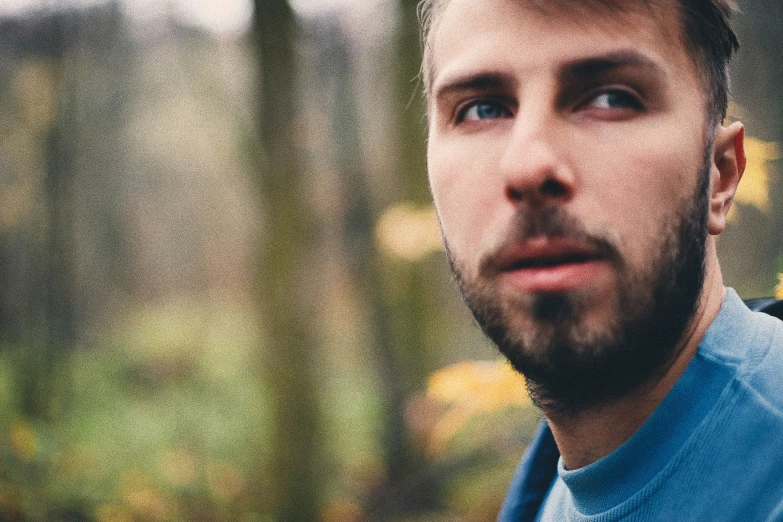 this is a man in a blue shirt and some trees