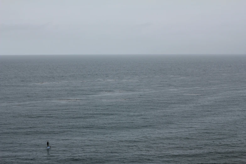 a lone person standing in a calm ocean