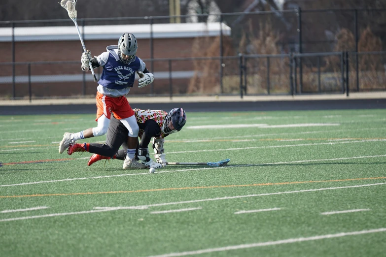 two men are playing soccer while holding the same lacrosse stick
