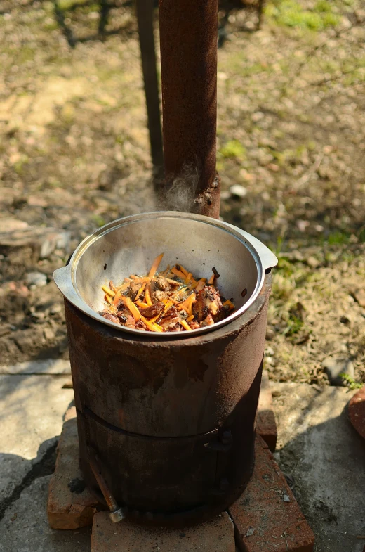 a pot full of food near a wooden pole