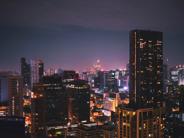 some buildings at night time and lights on the top of them