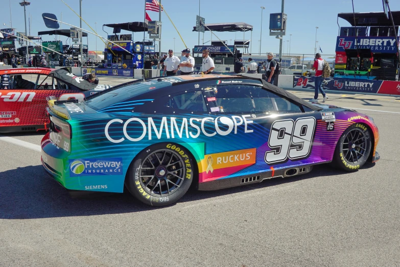 a rainbow race car sitting on top of a parking lot