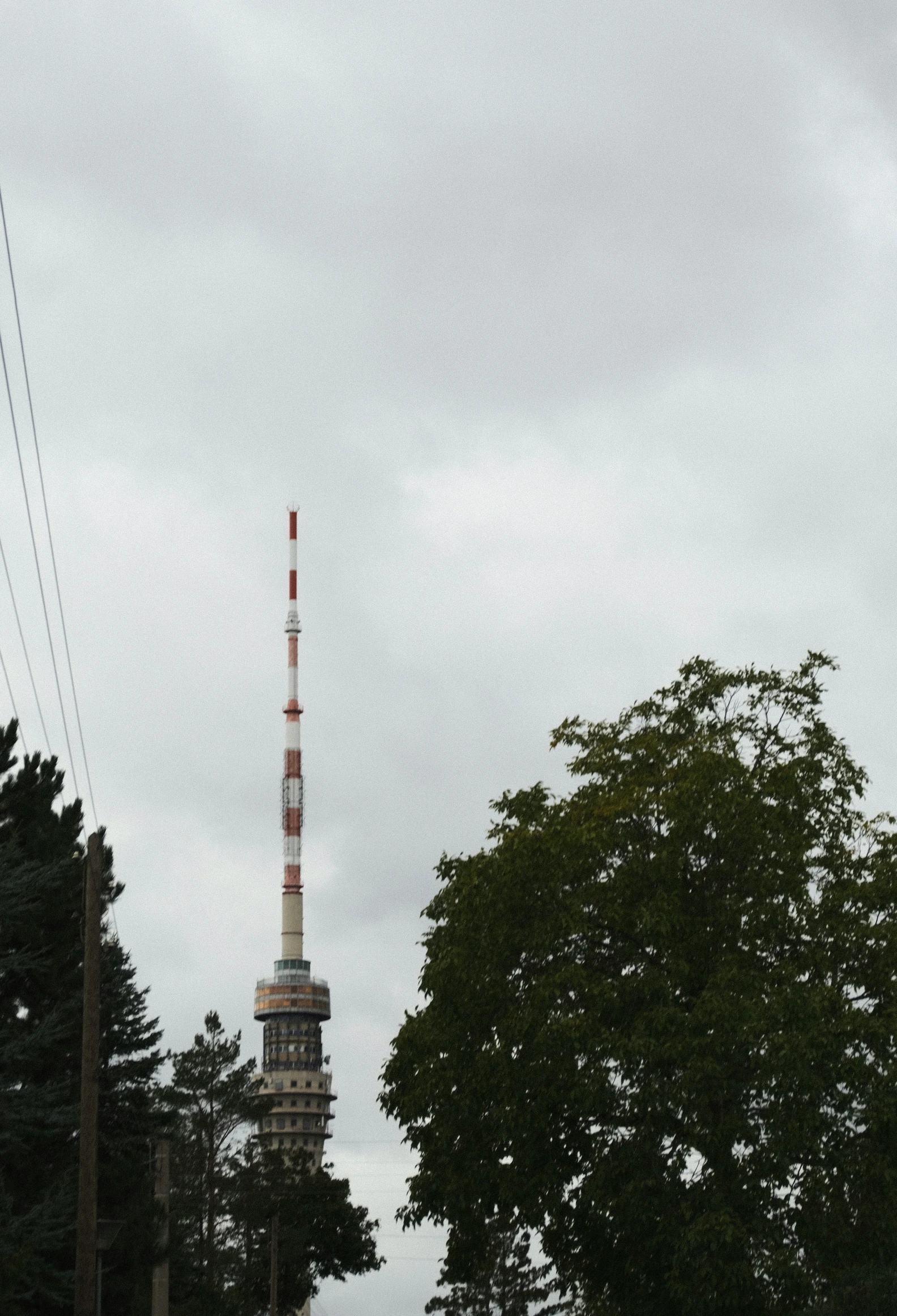 a tall tower towering over a street next to some trees