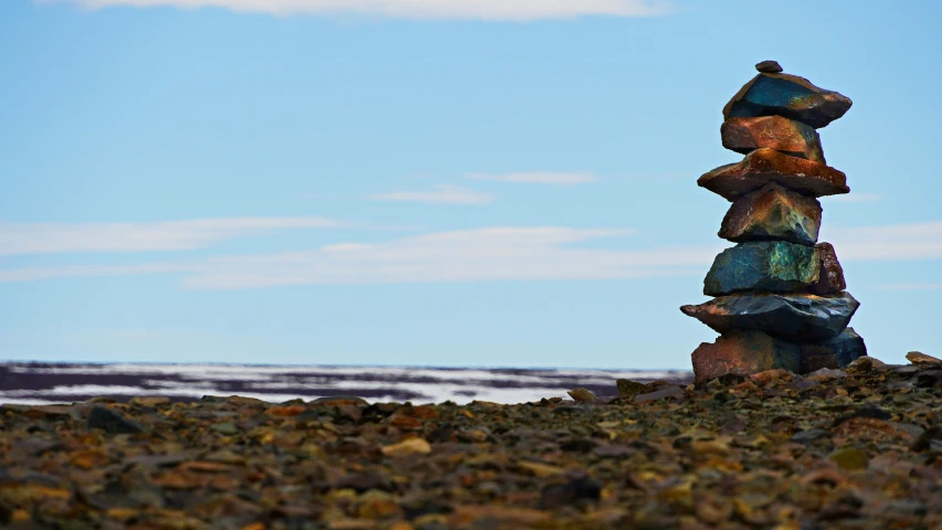 the small statue is in front of the rocky outcrop