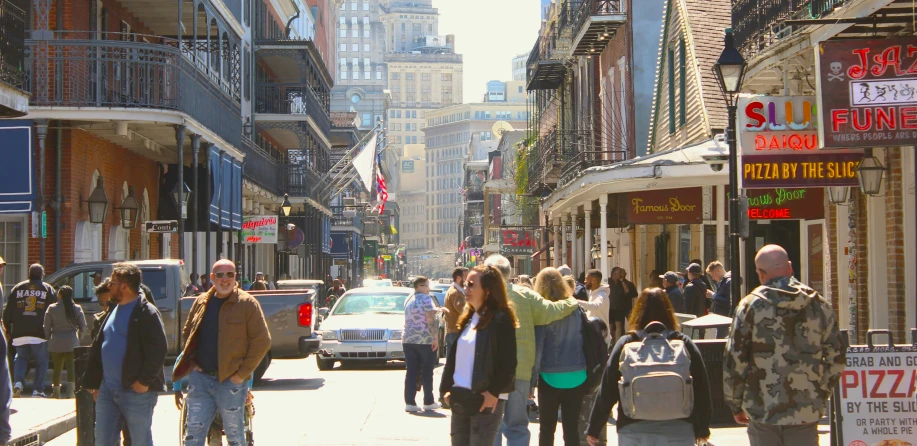 many people walking on the sidewalk in a busy city