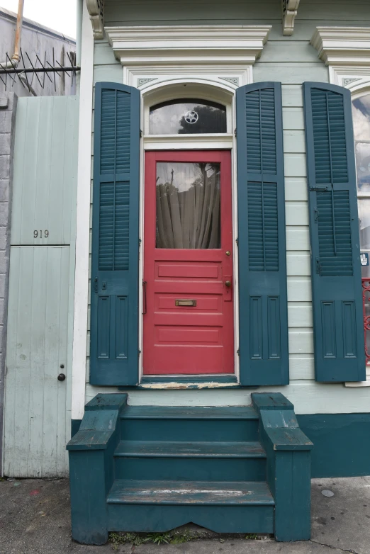 the door is painted bright blue and the shutters are closed