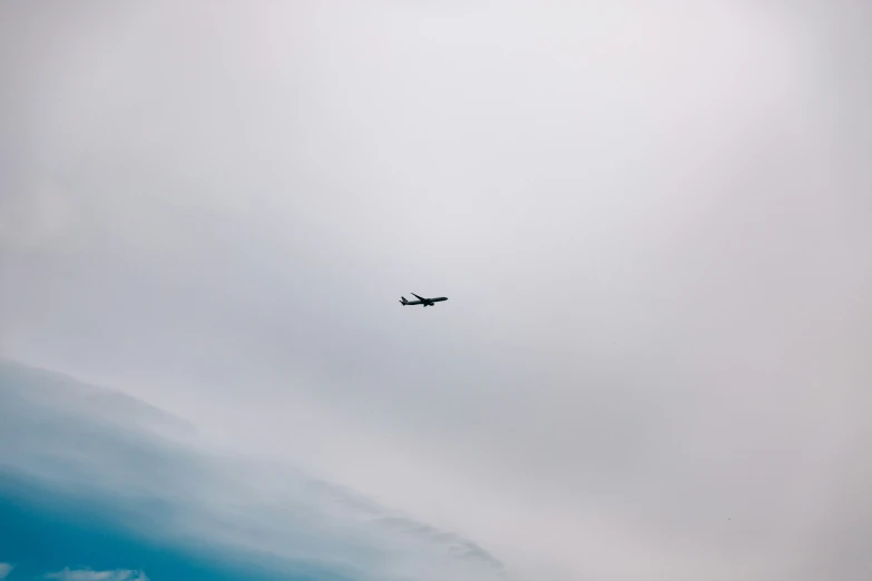 an airplane flying in a cloudy sky with a cloud in the background