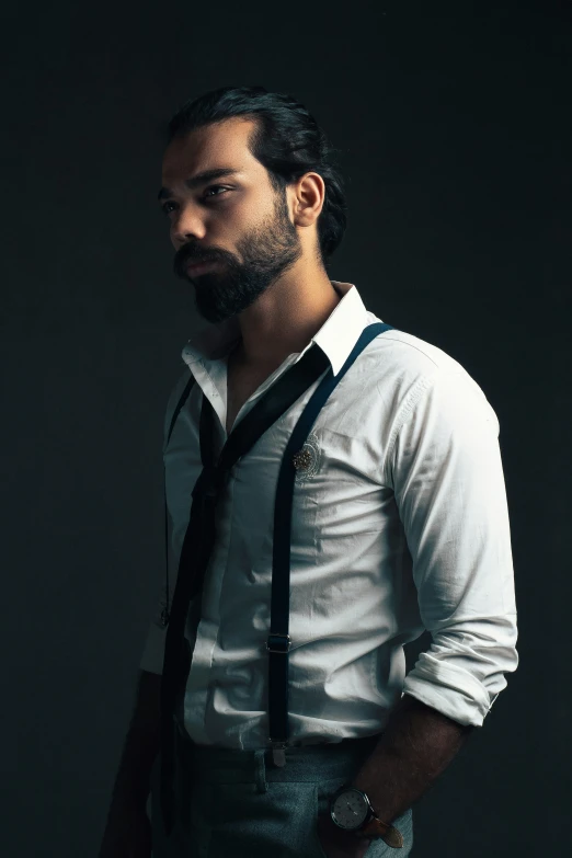 a man standing up wearing suspenders and a tie