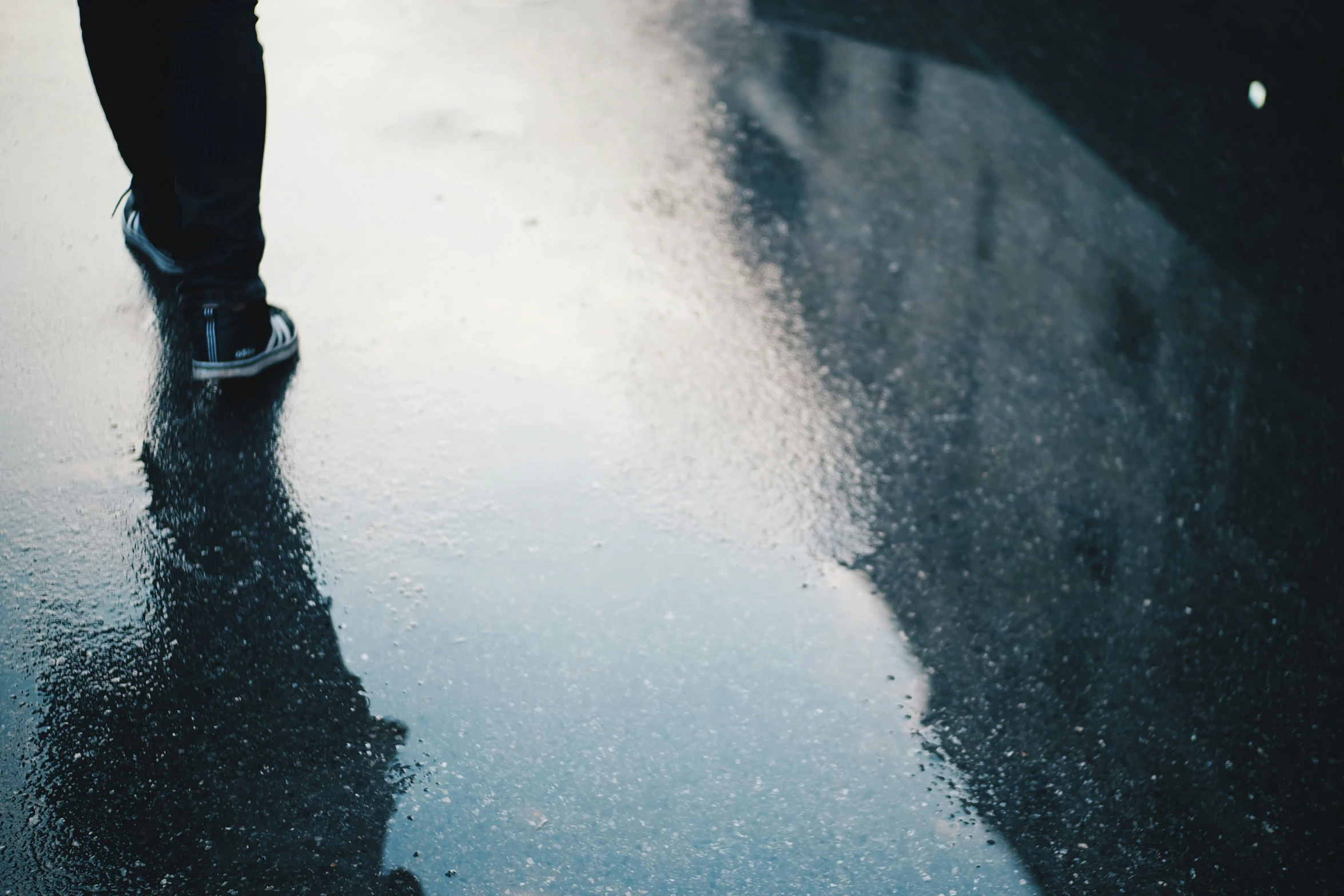 a person standing on top of a rain soaked street