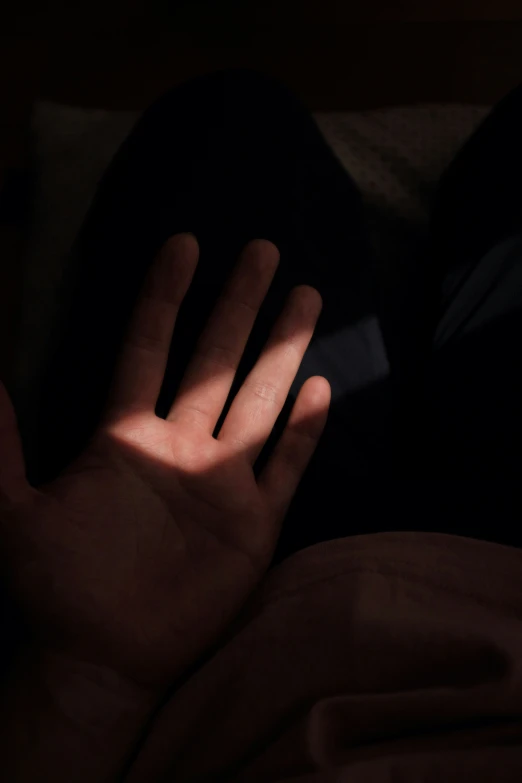 person's shadow from their hand against a dark background