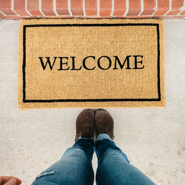 two legs that are on the ground next to a welcome mat