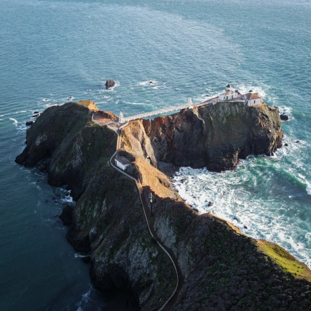 two large rocks on a coast line next to the ocean