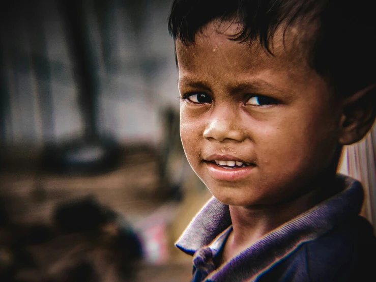 young child with blue eyes looking away while standing outside