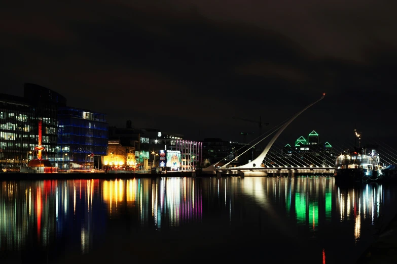 a view of the river with a bridge and skyscrs at night