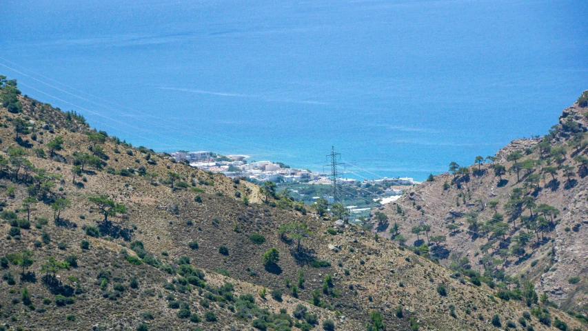 a large blue body of water sitting on top of a lush green hill