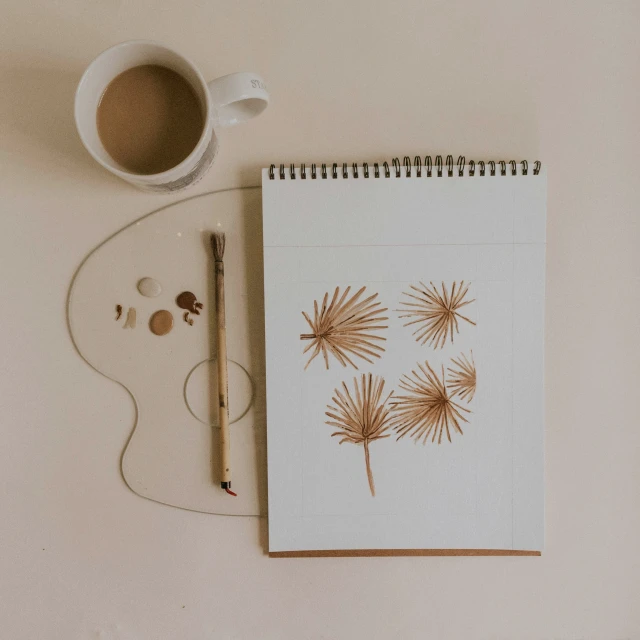 a drawing book and a cup with a pencil