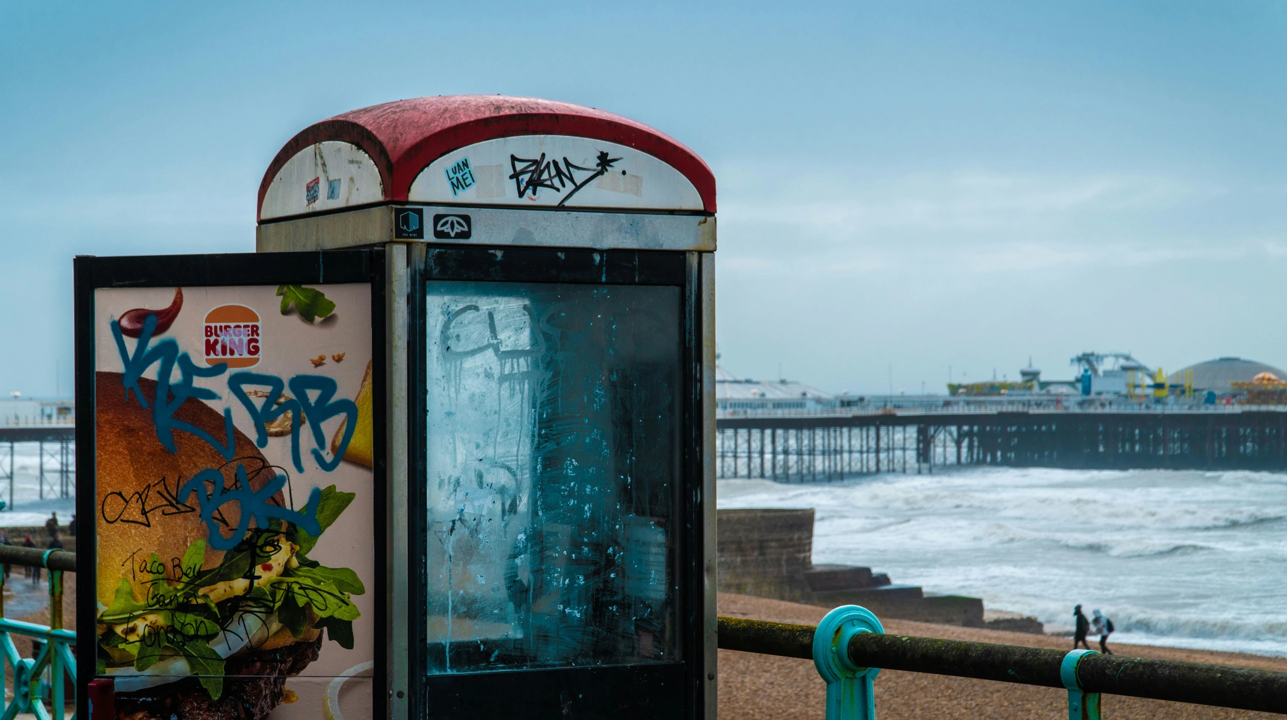 a very odd looking phone booth next to the water