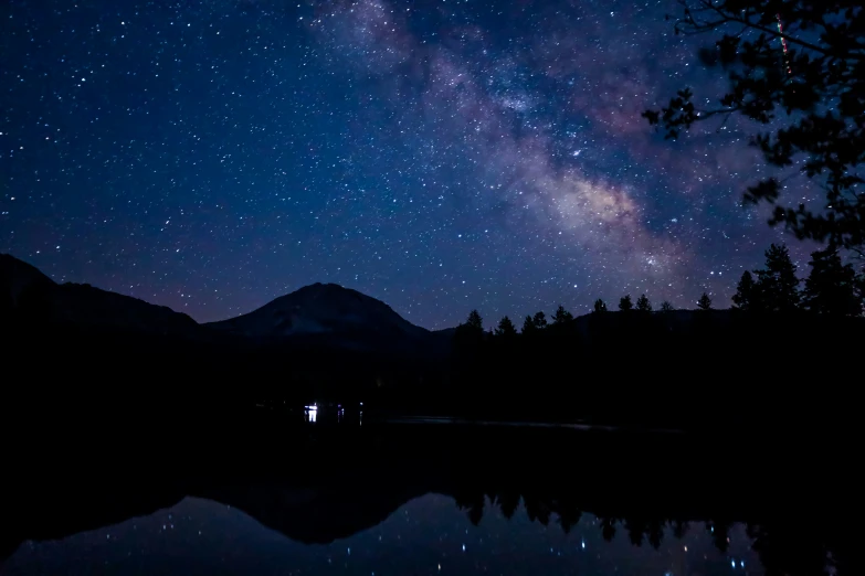 the stars and the mountain reflecting in the water