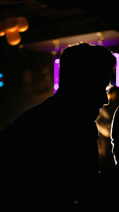 two silhouettes of people in a dark room