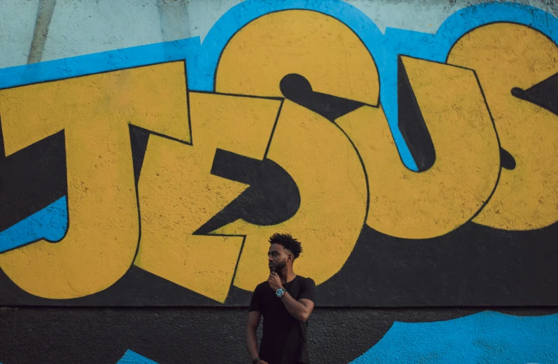 a man walking past a wall with graffiti