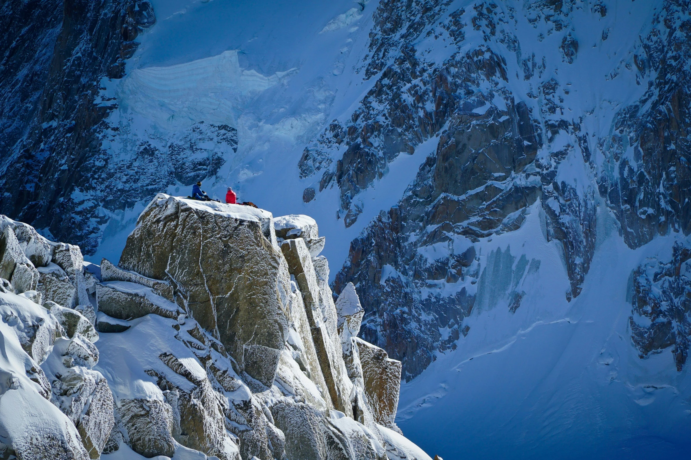 the skiers are taking their way up the mountain slope