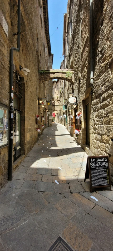 an alley between buildings with a sign in the foreground