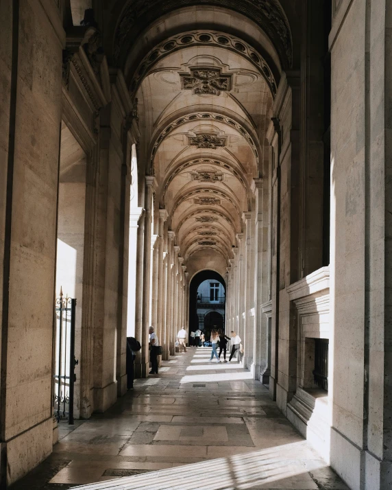 people walking down a hallway between some buildings