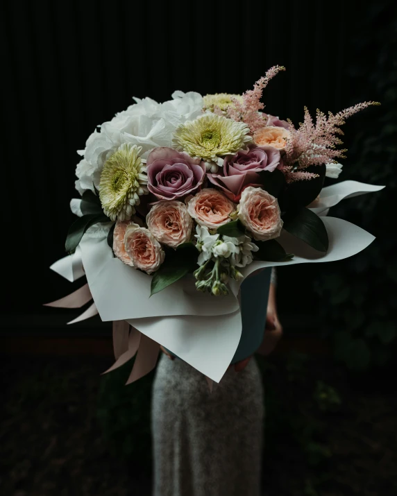 a bouquet of different flowers displayed on a woman