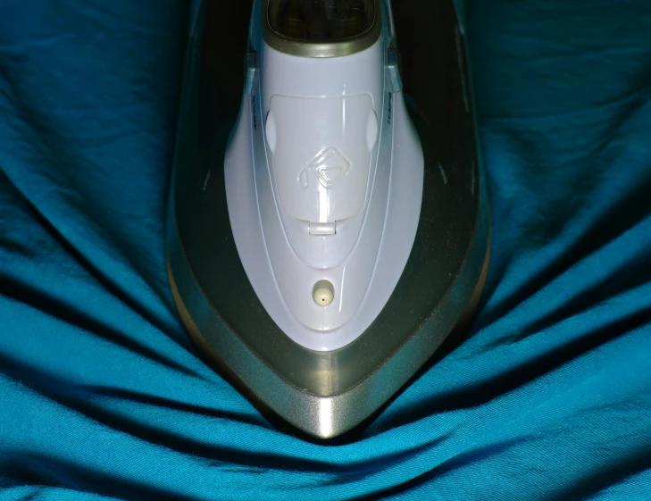 the front of a electric brush lying on a bed
