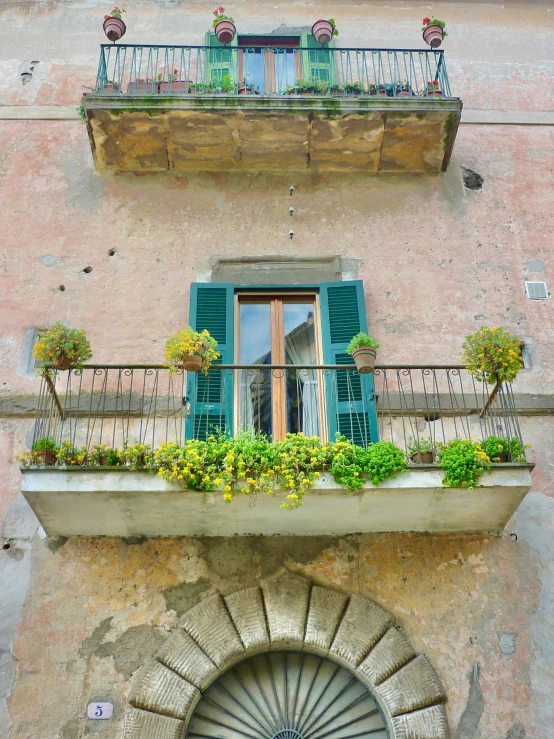 an apartment building with green balconies, windows and shutters