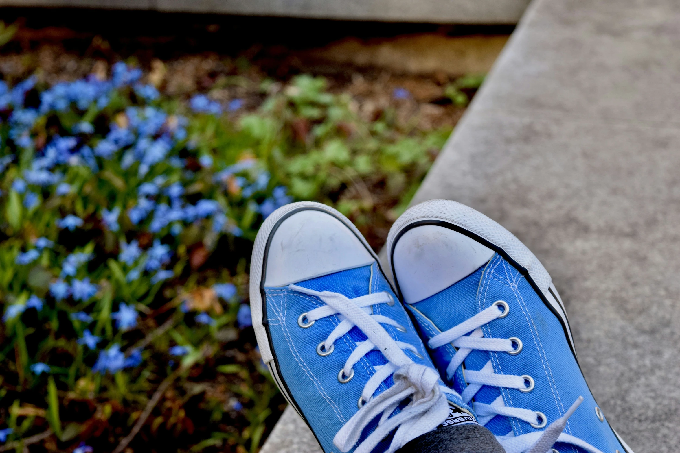 the feet are in blue shoes with laces on them