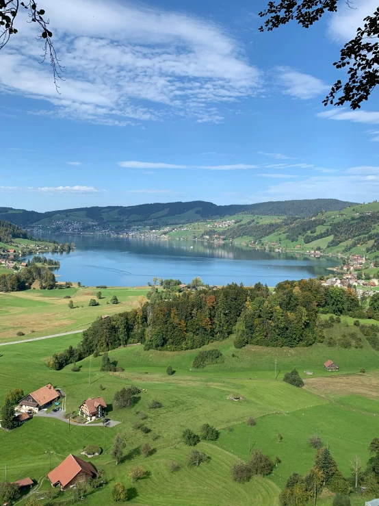 an image of a green land with a lake in the distance