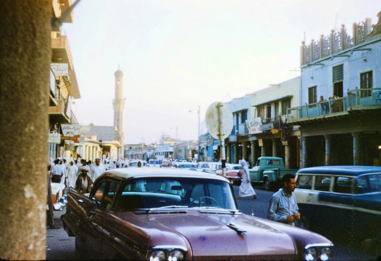 a street filled with cars and buildings next to people