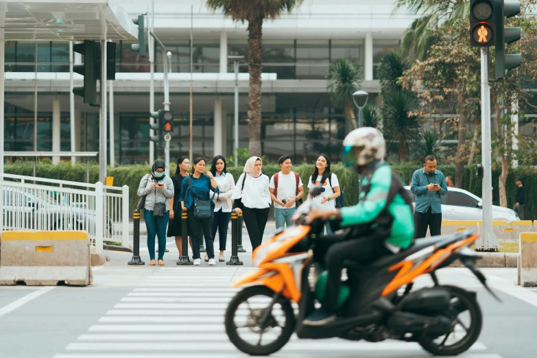 people watch as a guy riding his motorcycle passes by