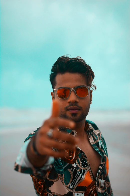 a man wearing sunglasses with a peace sign on his finger