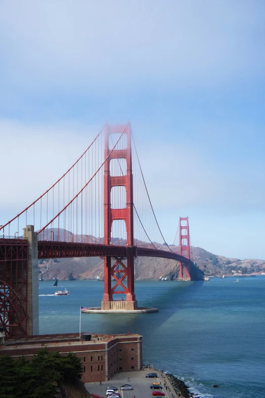 cars passing underneath the golden gate bridge in san francisco, california