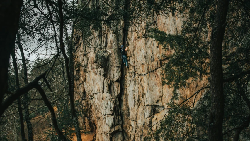 two climbers climb up the side of a tall rock