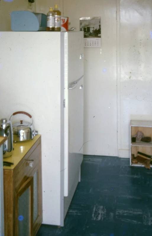 a small white refrigerator next to a blue floor