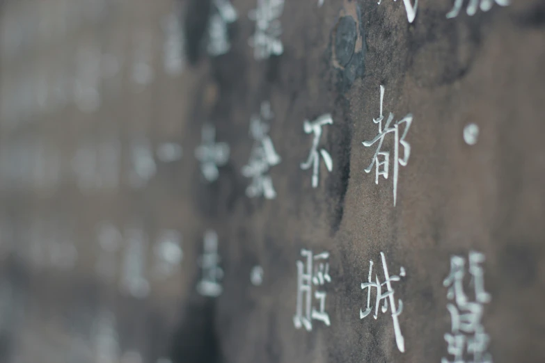 some writing on some cement with chinese characters