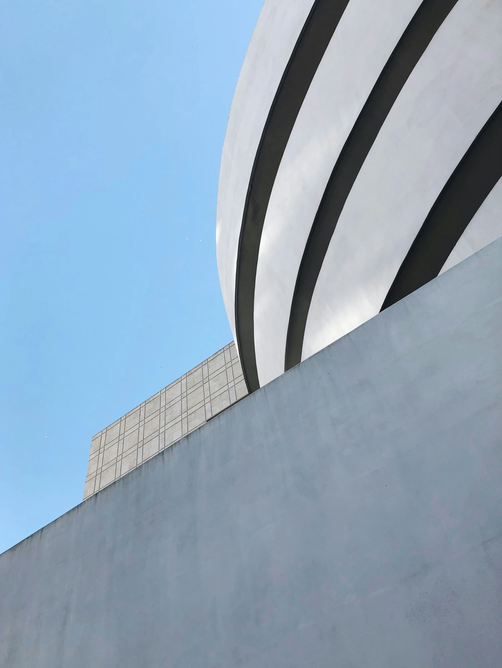 a man stands in a skateboard park by a large concrete structure