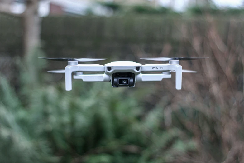 a camera attached to the back of a white flying device