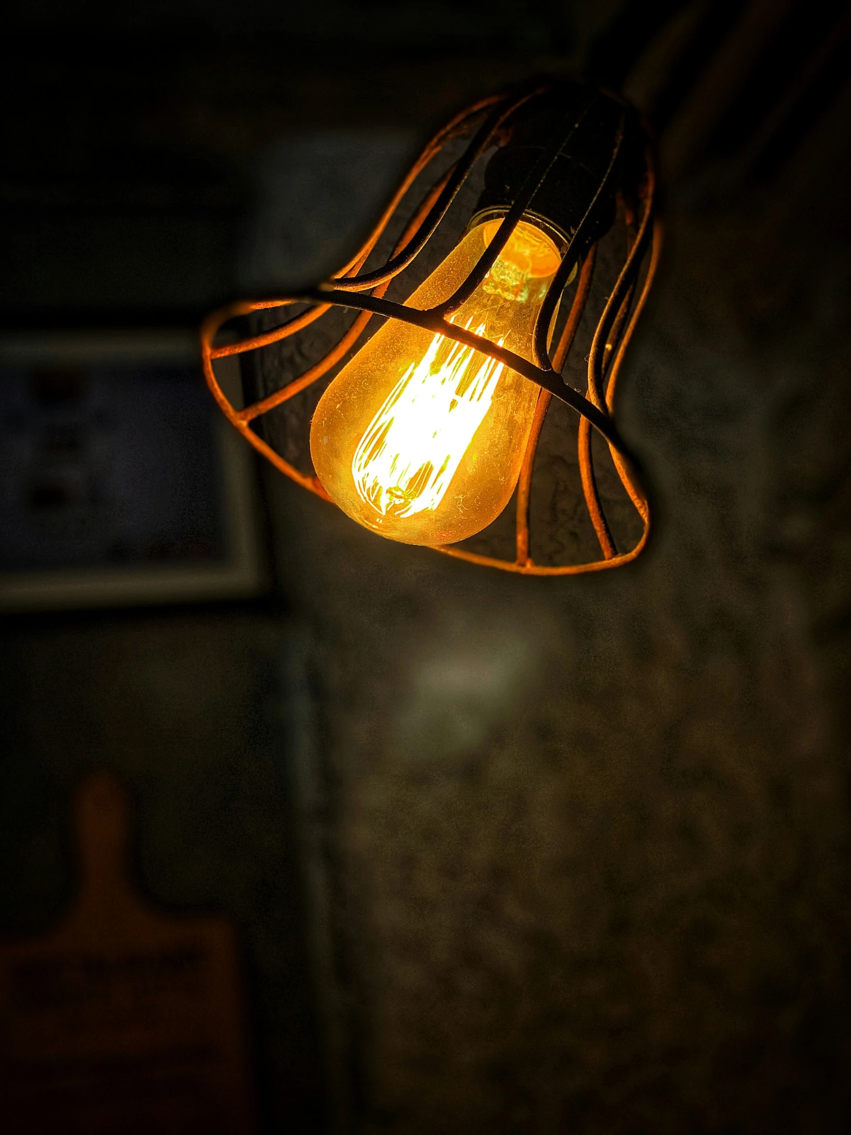 two orange light bulbs hanging from the side of a light
