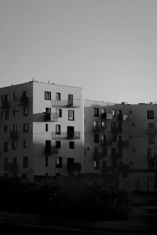 a large building sitting between two rows of apartments