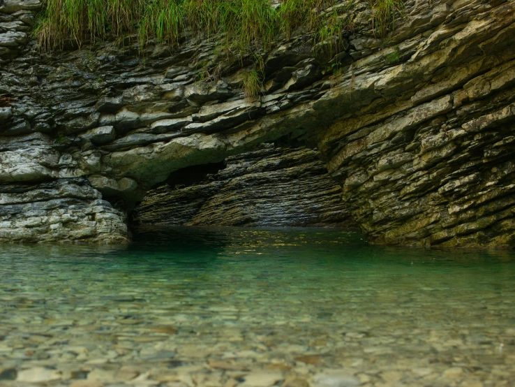 an open body of water is next to the rocky mountains